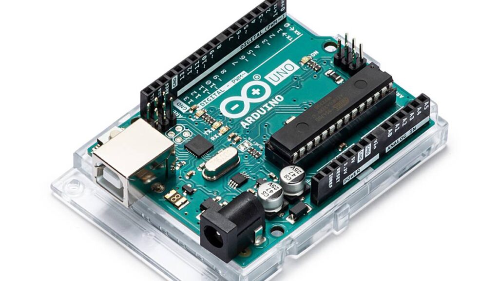 青緑色の回路基板を備えた Arduino Uno ボード。USB ポート、電源ジャック、マイクロコントローラ、電子部品を接続するためのさまざまなピンがあります。Arduino のロゴと「UNO」が見えます。ボードは透明なベースに取り付けられています。.